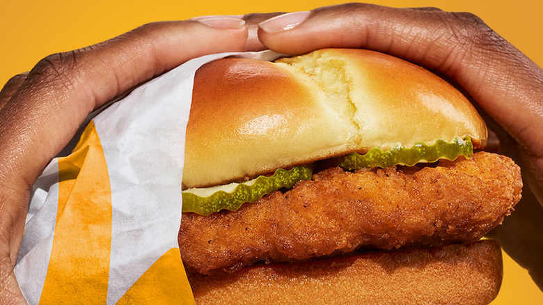 hands holding a McDonald's crispy chicken sandwich