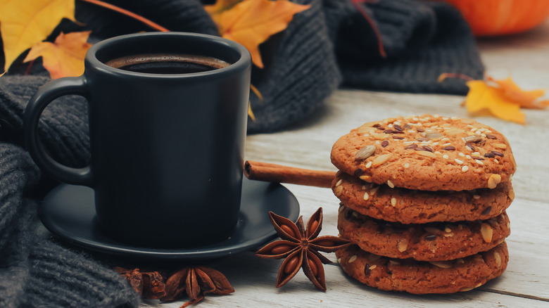 Pumpkin spice cookies alongside black mug with cinnamon