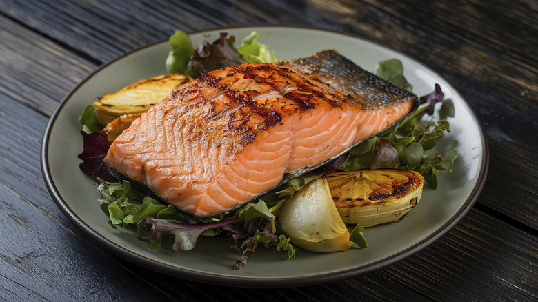 Grilled salmon on plate wtih greens