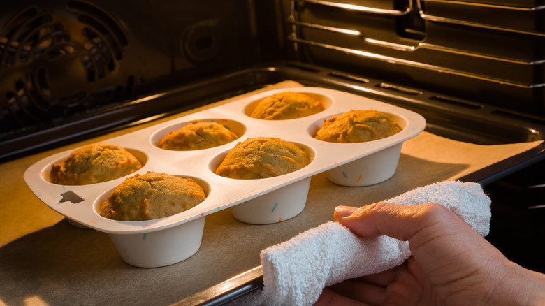 Rotating tray of muffins with open oven