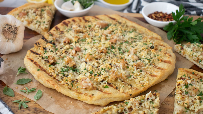 White clam pizza surrounded by more slices of pizza