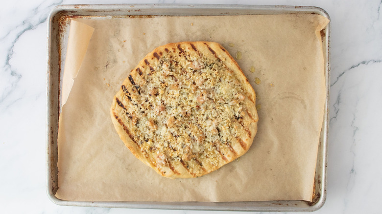 Baked white clam pizza on lined baking sheet