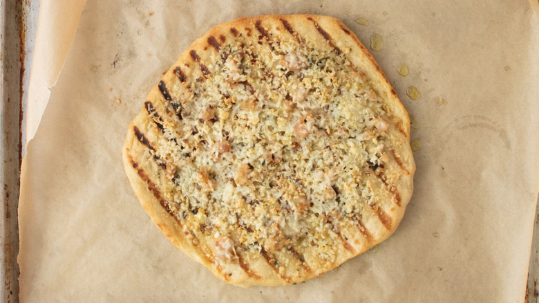 Baked white clam pizza on lined baking sheet