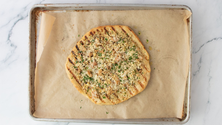 White clam pizza topped with parsley on baking sheet