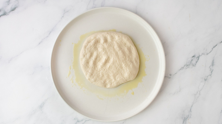 Pizza dough and olive oil on plate