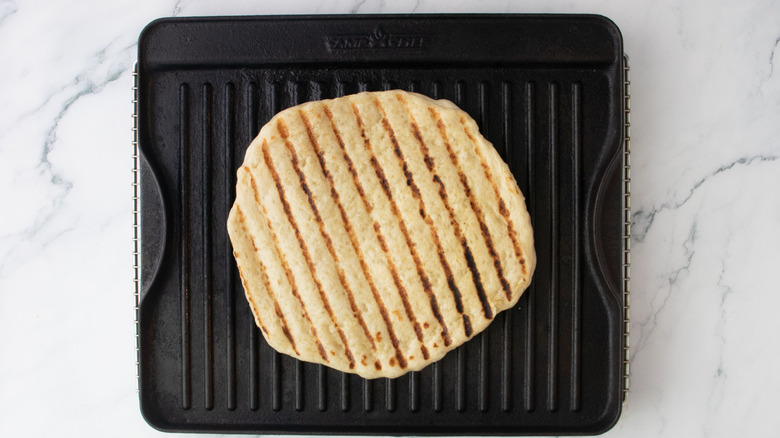 Pizza dough with grill marks on grill pan