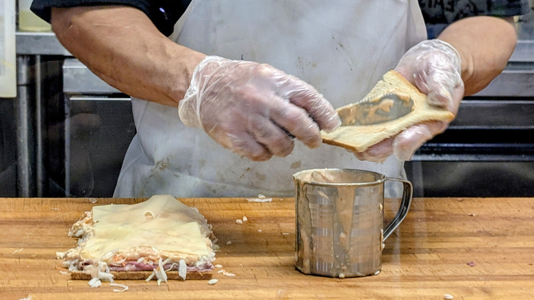 Person spreads Russian dressing on a sloppy joe sandwich at Town Hall Deli in South Orange, New Jersey