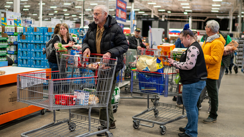 Costco employee scanning customer groceries while in line