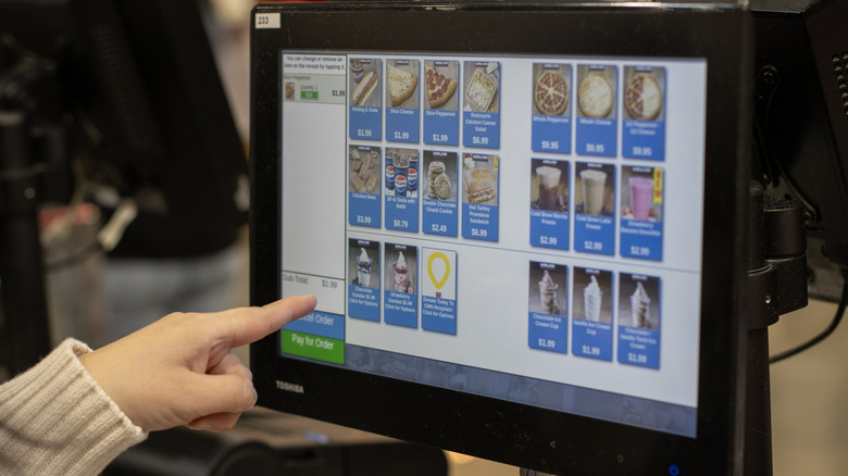 Person ordering food on a screen from Costco food court