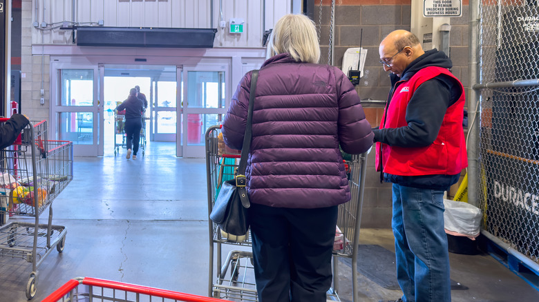 Costco employee checking customer receipt at the door