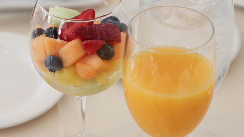 Glass of orange juice next to fruit