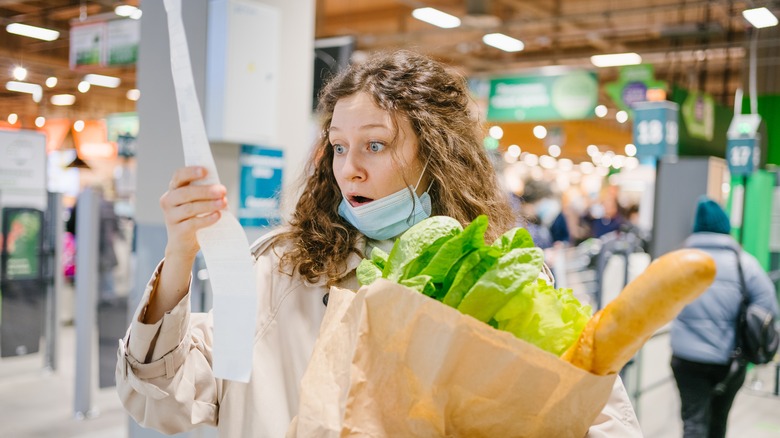 woman looking at grocery receipt