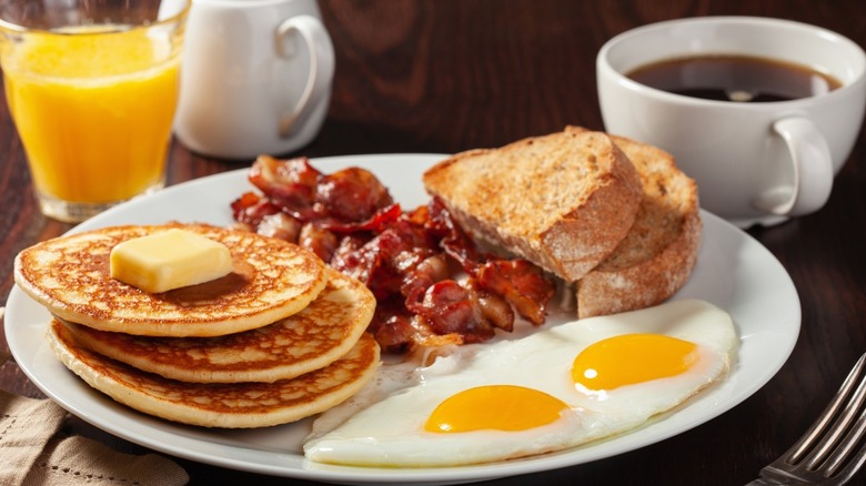 Breakfast of pancakes, bacon, eggs, and toast