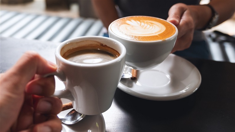 Two coffee cups cheersing