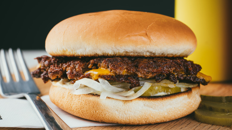 Beef smash burger with onion, cheese, and pickles