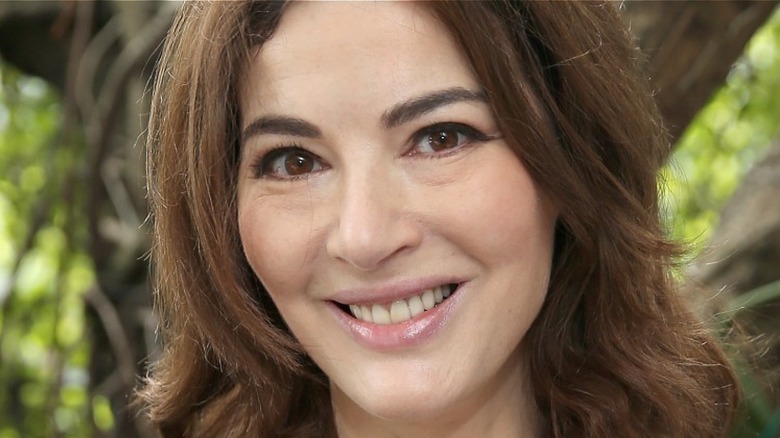 Nigella Lawson smiling near tree