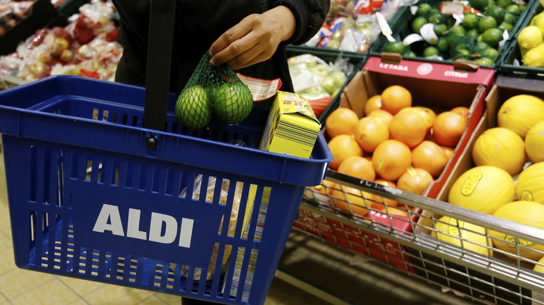 person holding an Aldi shopping basket