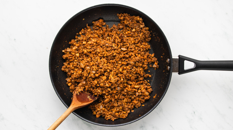 Lentil, walnut, and breadcrumb mixture sauteing in frying pan