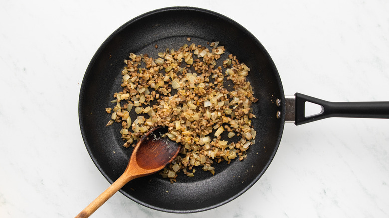 Sauteed onion and mushroom stems in frying pan