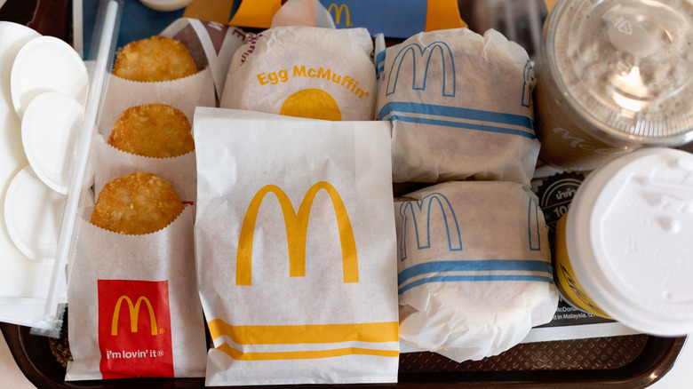McDonald's breakfast food and beverages spread out on tray inside the restaurant.