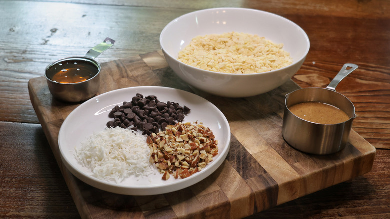Almond-Joy-inspired no-bake cereal bar ingredients on a cutting board on a wooden table