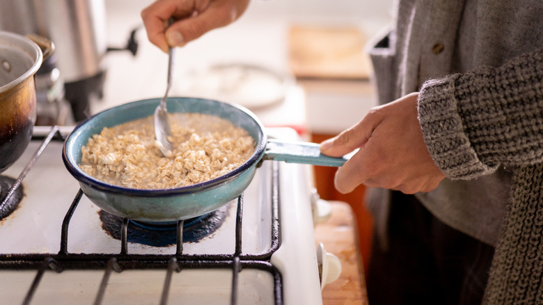 Person cooking oatmeal on stovetop