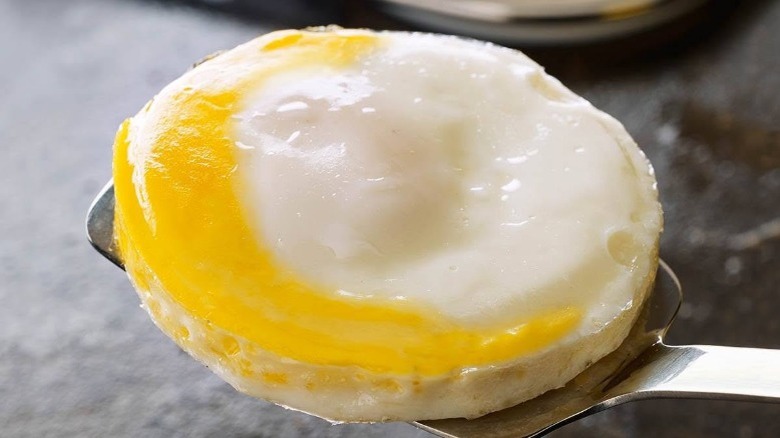 Round egg from McDonald's on metal spatula.