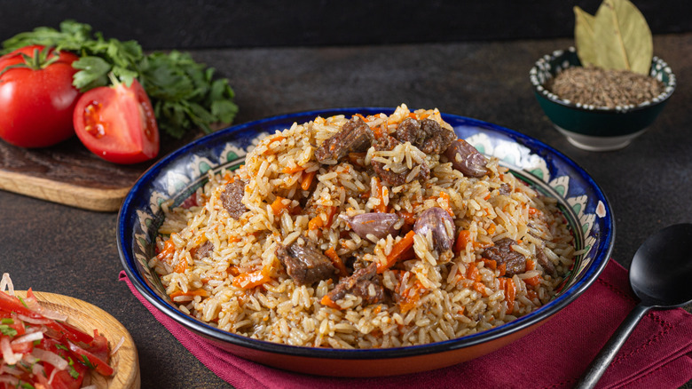 rice pilaf with chicken surrounded by peppers and seasoning