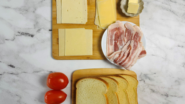 cheese, bread, butter, tomatoes, and uncooked bacon