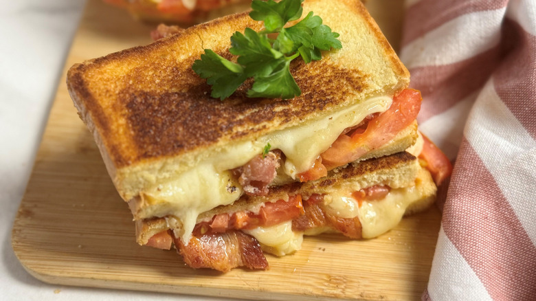 Bacon grilled cheese sandwich garnished with herb