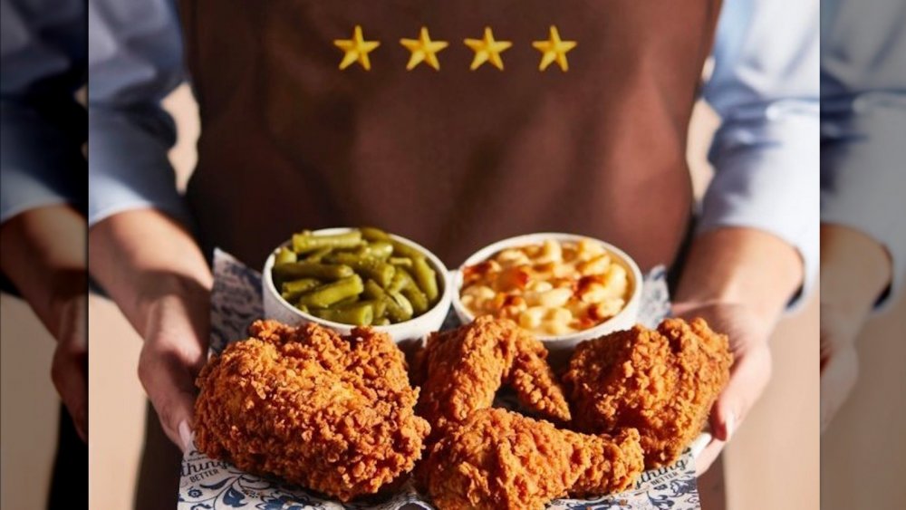 cracker barrel server holding a plate of fried chicken, green beans and macaroni and cheese  