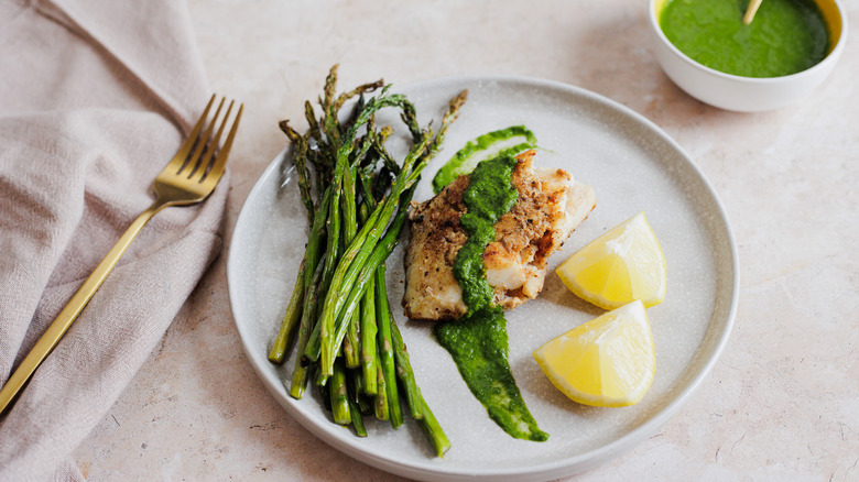 cod with green salsa and asparagus on plate