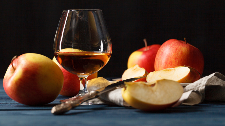Glass of Calvados apple brandy with fresh and sliced apples