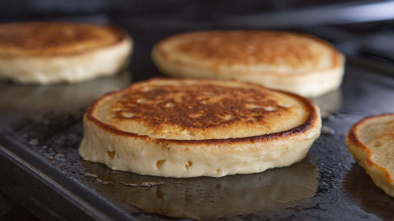 four pancakes on greased griddle