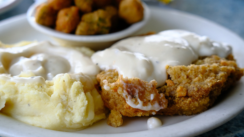 plate of food including mashed potatoes and country gravy