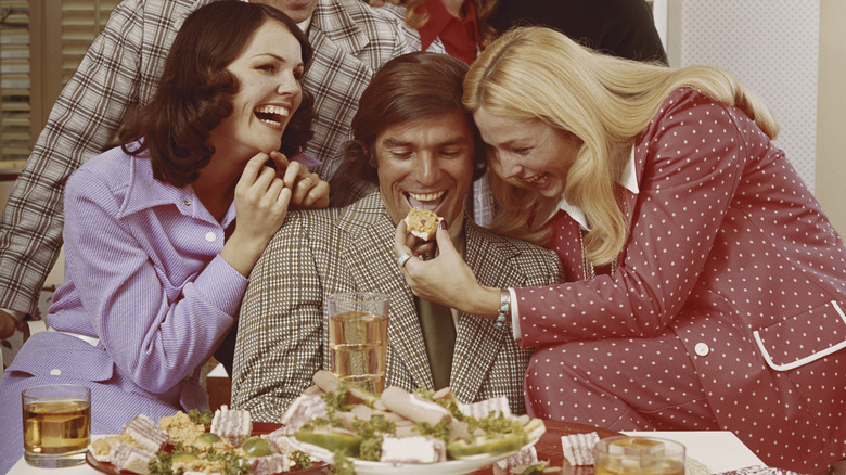 1970s era people eating food and laughing