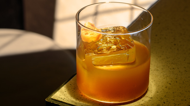 glass of liquor with ice cube
