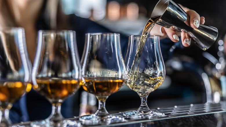 liquor being poured into various glasses