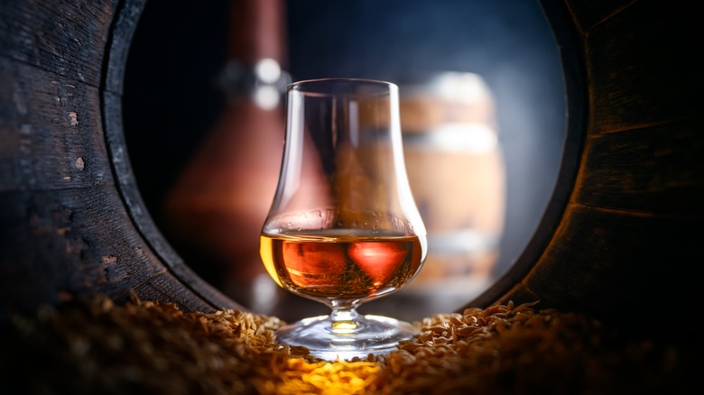 brown liquor in glass in barrel
