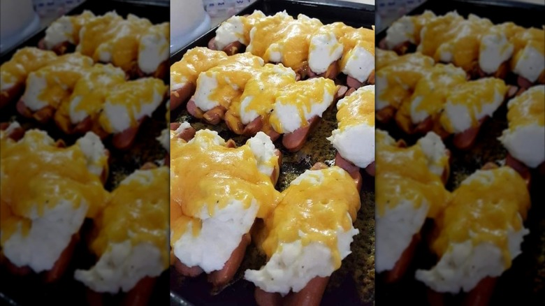 A tray filled with mashed potato stuffed hot dogs