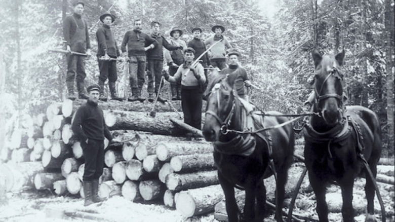 Black-and-white photo of lumberjacks and horses