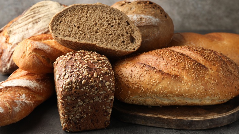 an assortment of breads on wooden chopping board