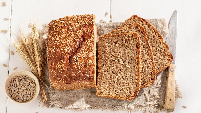 wheat and rye loaf with dried wheat and a knife