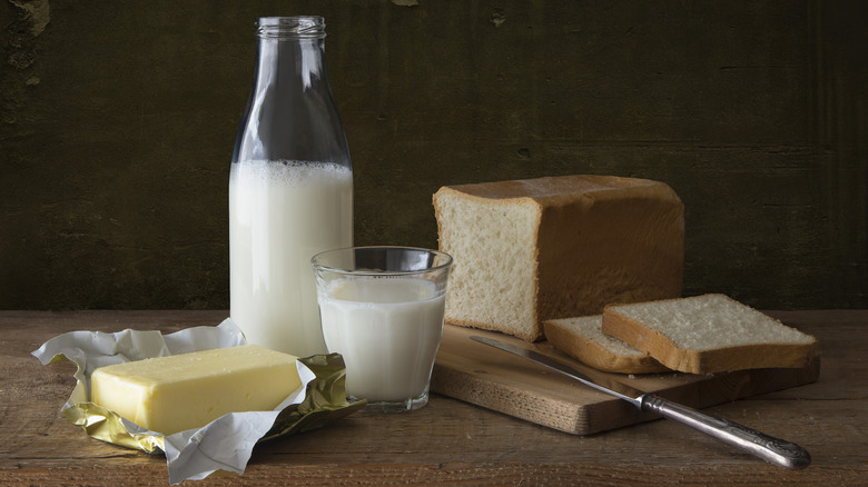 Butter, jar and glass of milk, cut bread