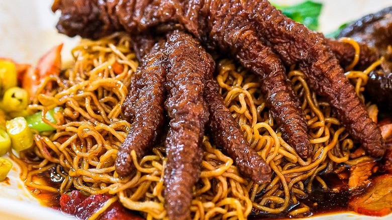Close-up of chicken feet on a bed of noodles