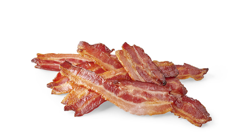 A close-up of crispy bacon against a white background
