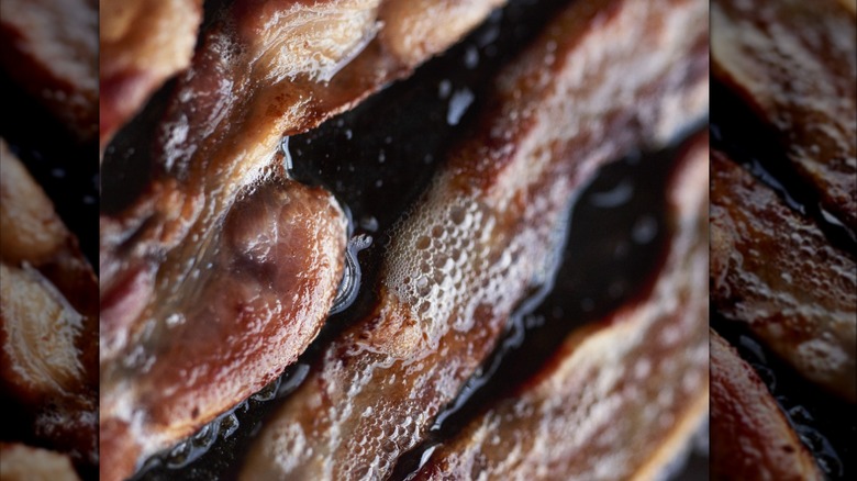 Strips of bacon frying in a pan
