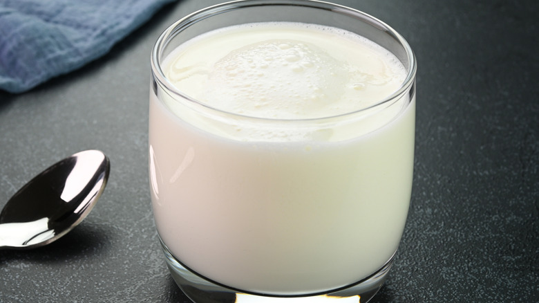 buttermilk in a stout glass beside a spoon