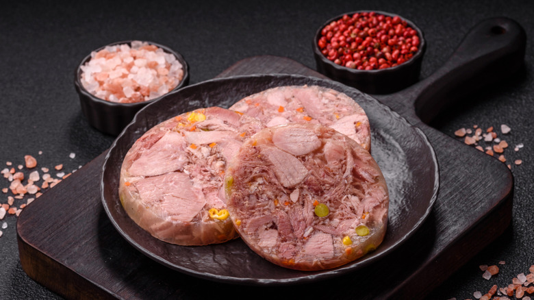 head cheese on a black metal plate beside spices