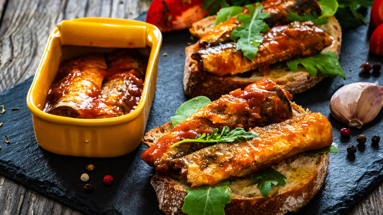 sardines in a tin and on bread with leafy greens